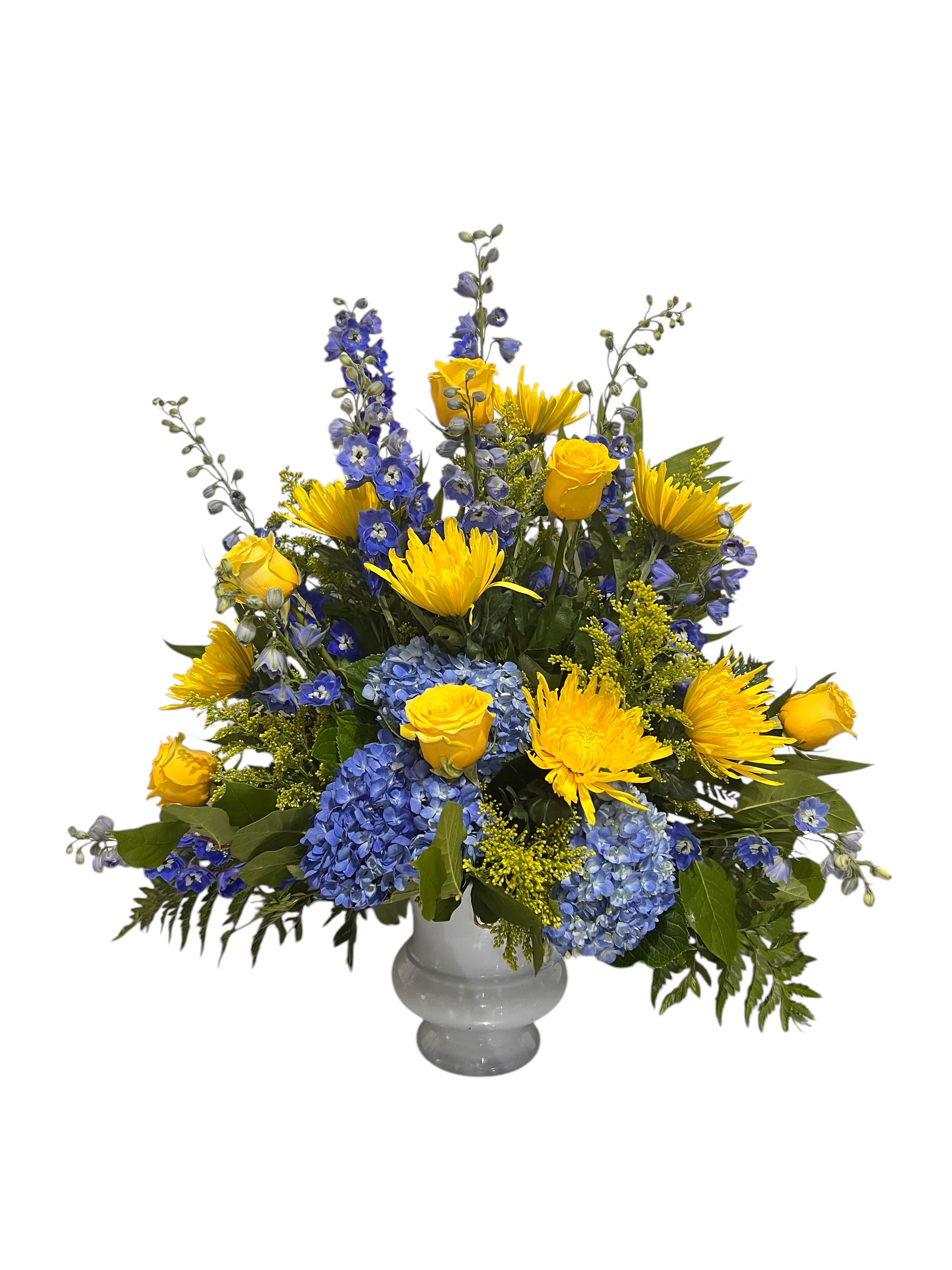 Yellow roses and blue flowers arranged in a gray vase