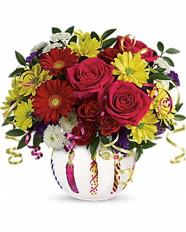 Bouquet of red roses and yellow daisies in a white vase with curling ribbons