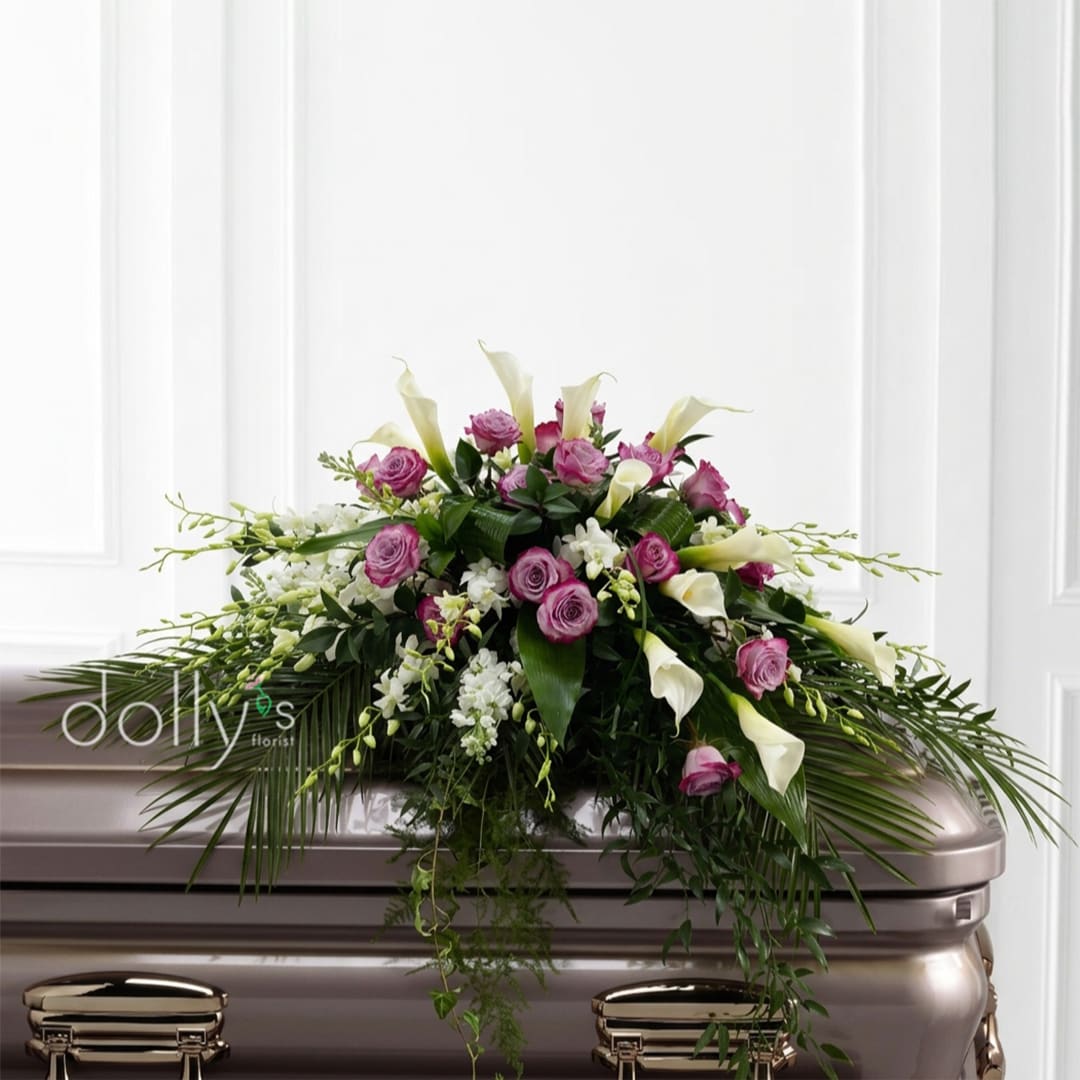 Pink roses and white calla lilies arranged on a casket