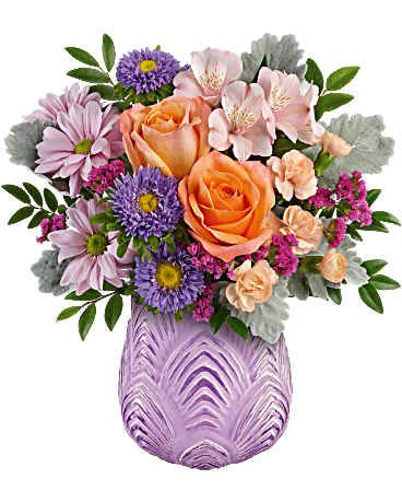 Bouquet of peach roses, purple daisies, and pink alstroemeria in a lavender vase