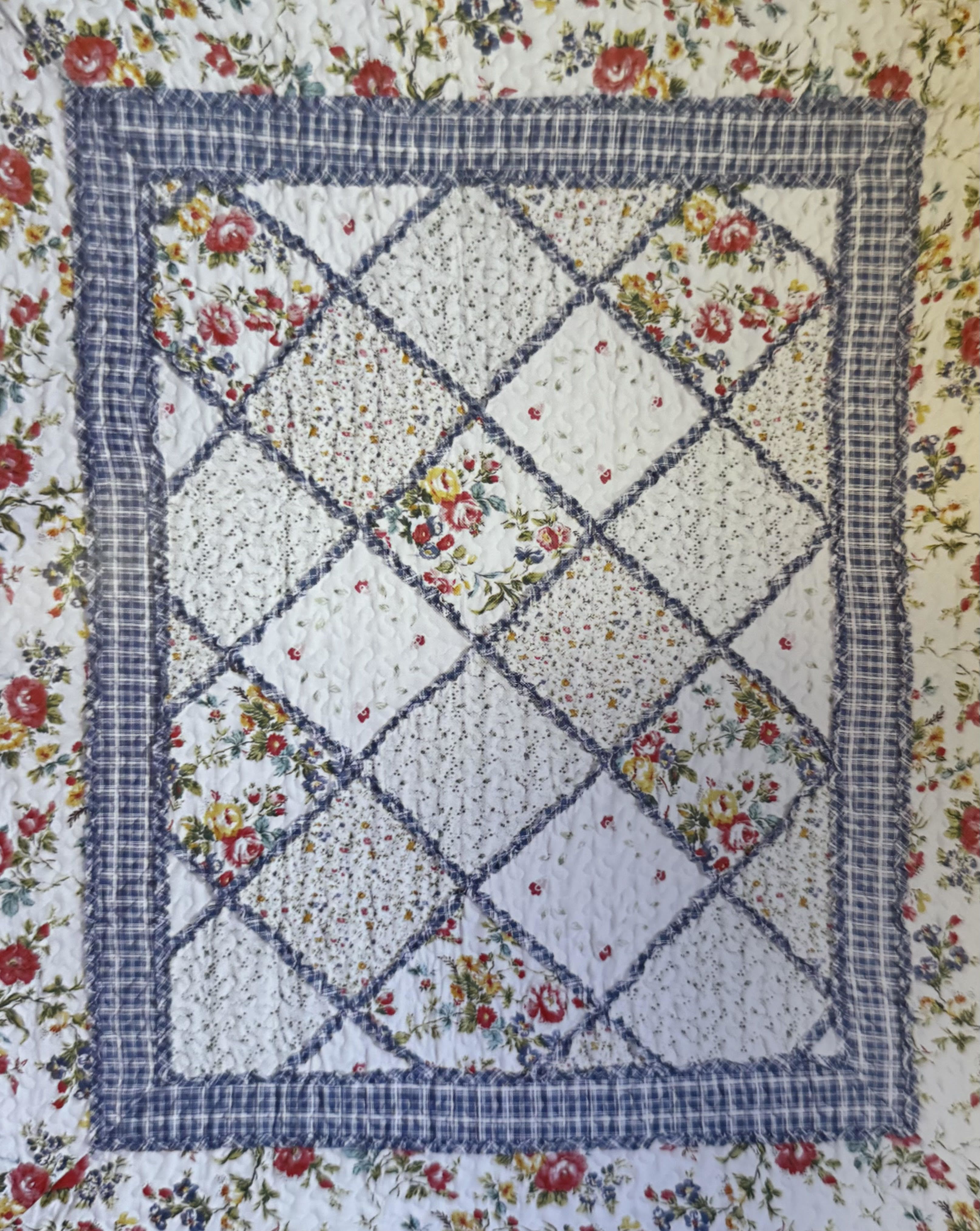 Floral patchwork quilt with blue plaid borders