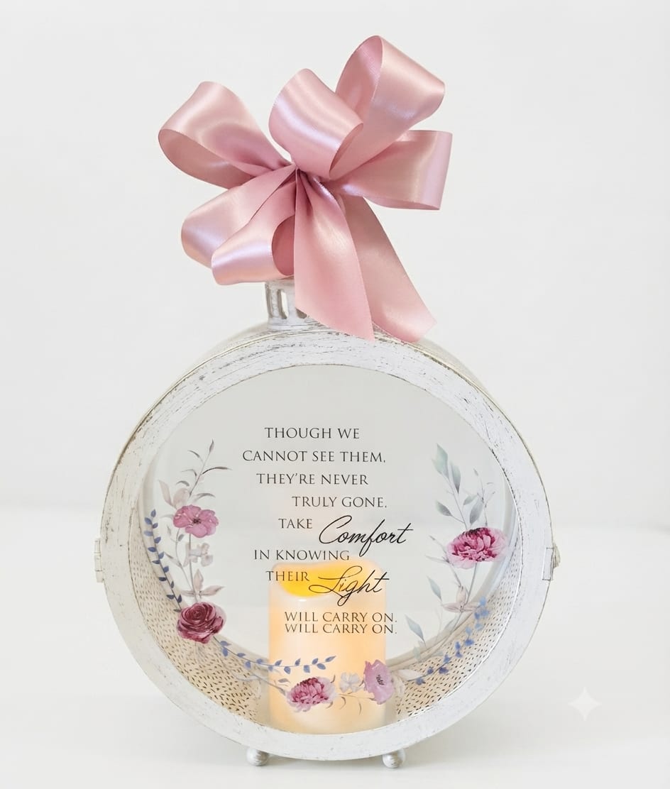Round memorial plaque with a pink ribbon bow and candle design