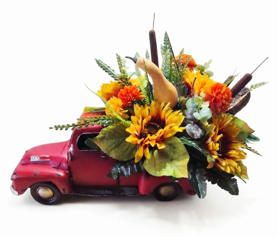 Sunflower and autumn floral arrangement in a red vintage truck container