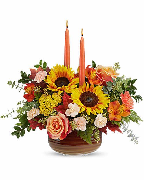 Teleflora's Fall's Harvest Centerpiece - Teleflora's Fall's Harvest Centerpiece glows with radiant sunflowers, rich autumn blooms, and elegant taper candles, gathered in Teleflora's Rustic Ember Bowl. With its warm, glazed finish and food-safe design, it creates a welcoming fall centerpiece that lingers beyond the moment. 