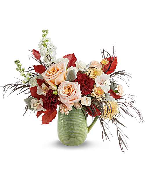 Teleflora's Pour It On Bouquet - Pour on the warmth of the season with Teleflora's Pour It On Bouquet, overflowing with rich fall blooms in Teleflora's Modern Sage Pitcher. With its soft, textured, food-safe design, this inviting fall bouquet brings a generous, gathered feel to any table.