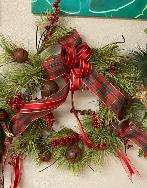 Holiday wreath with pine, red ribbon, berries, and bells