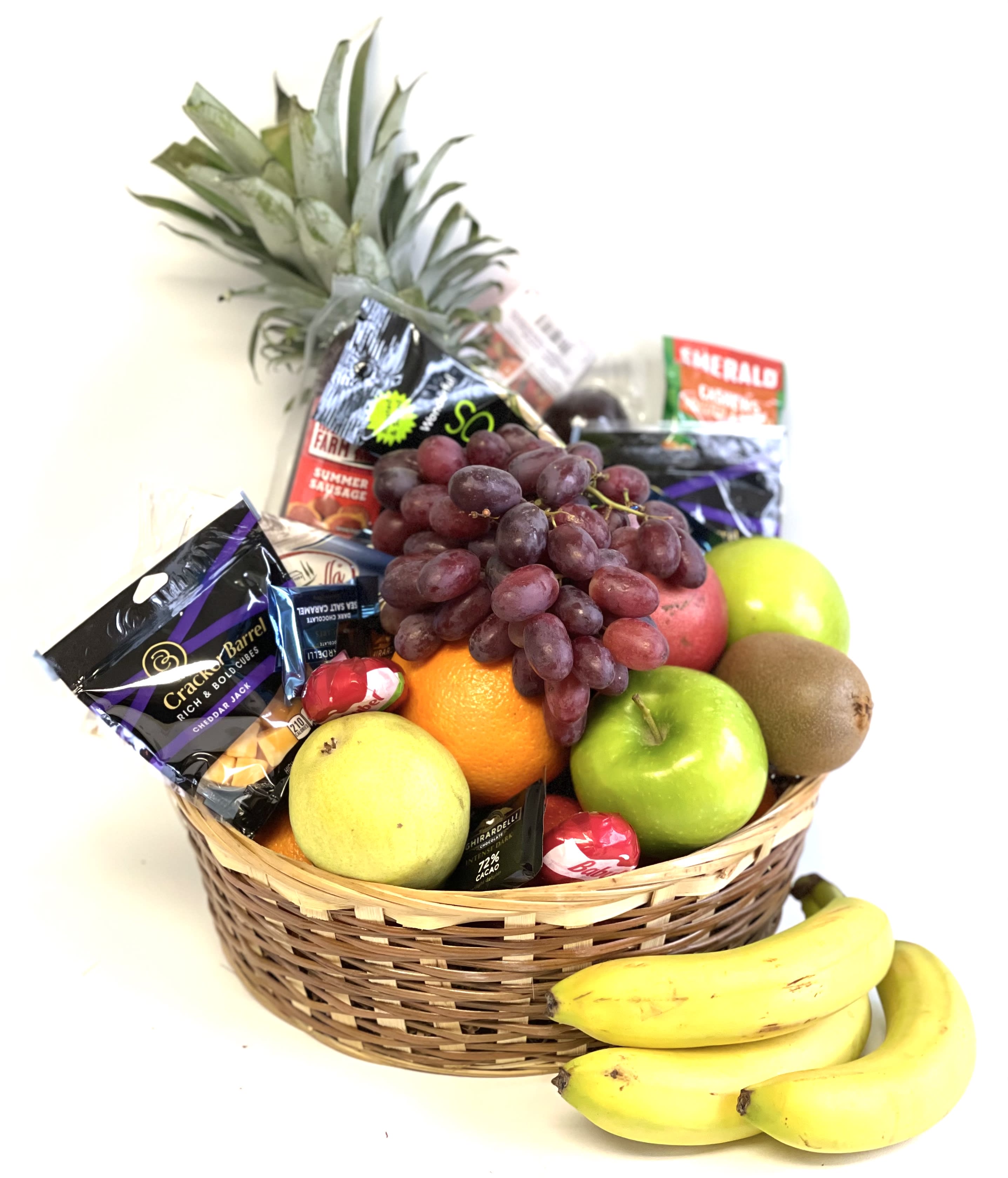 Fruit basket with grapes, apples, oranges, bananas, kiwi, and candy