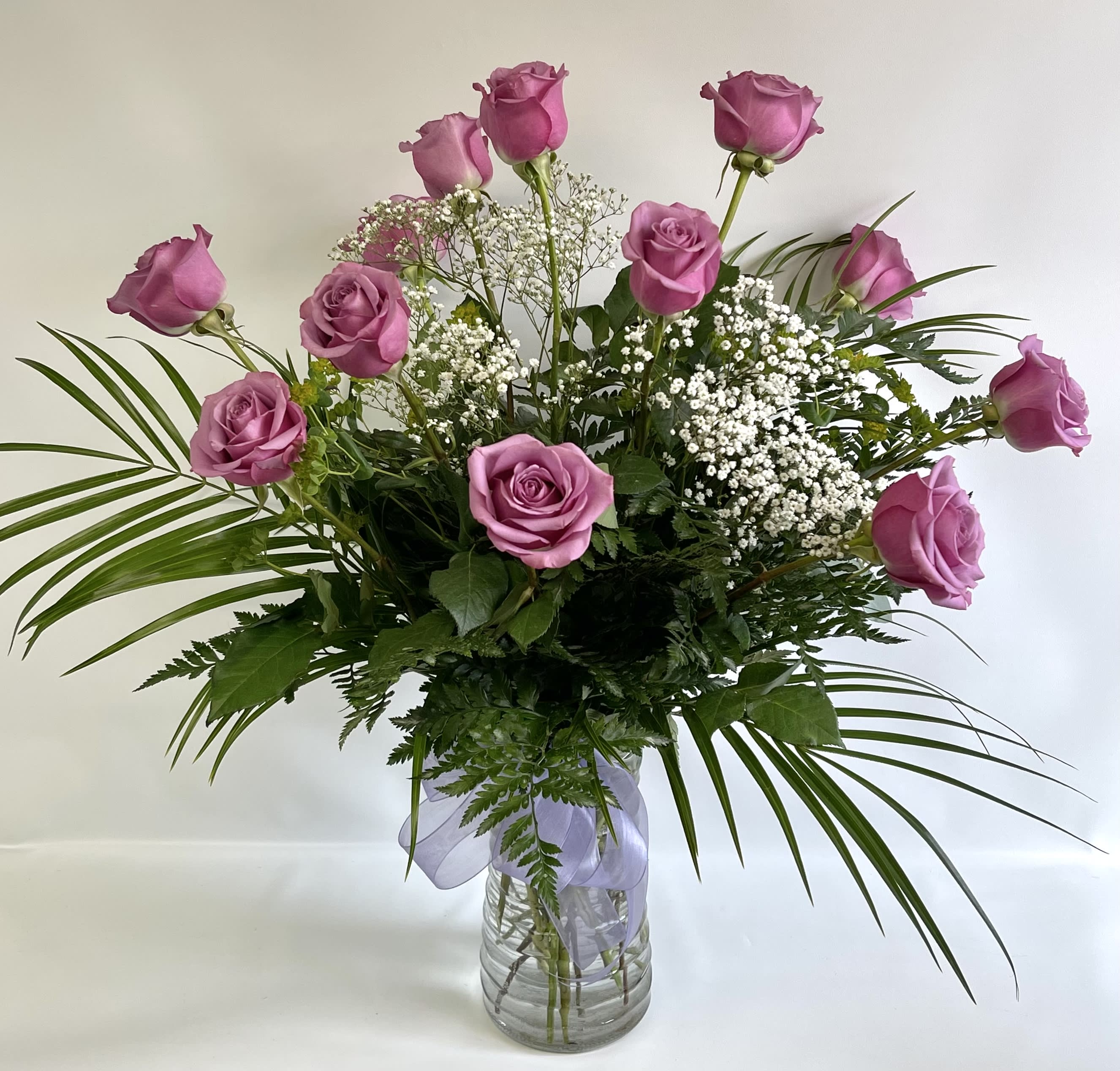 Pink roses arranged in a clear glass vase with baby's breath