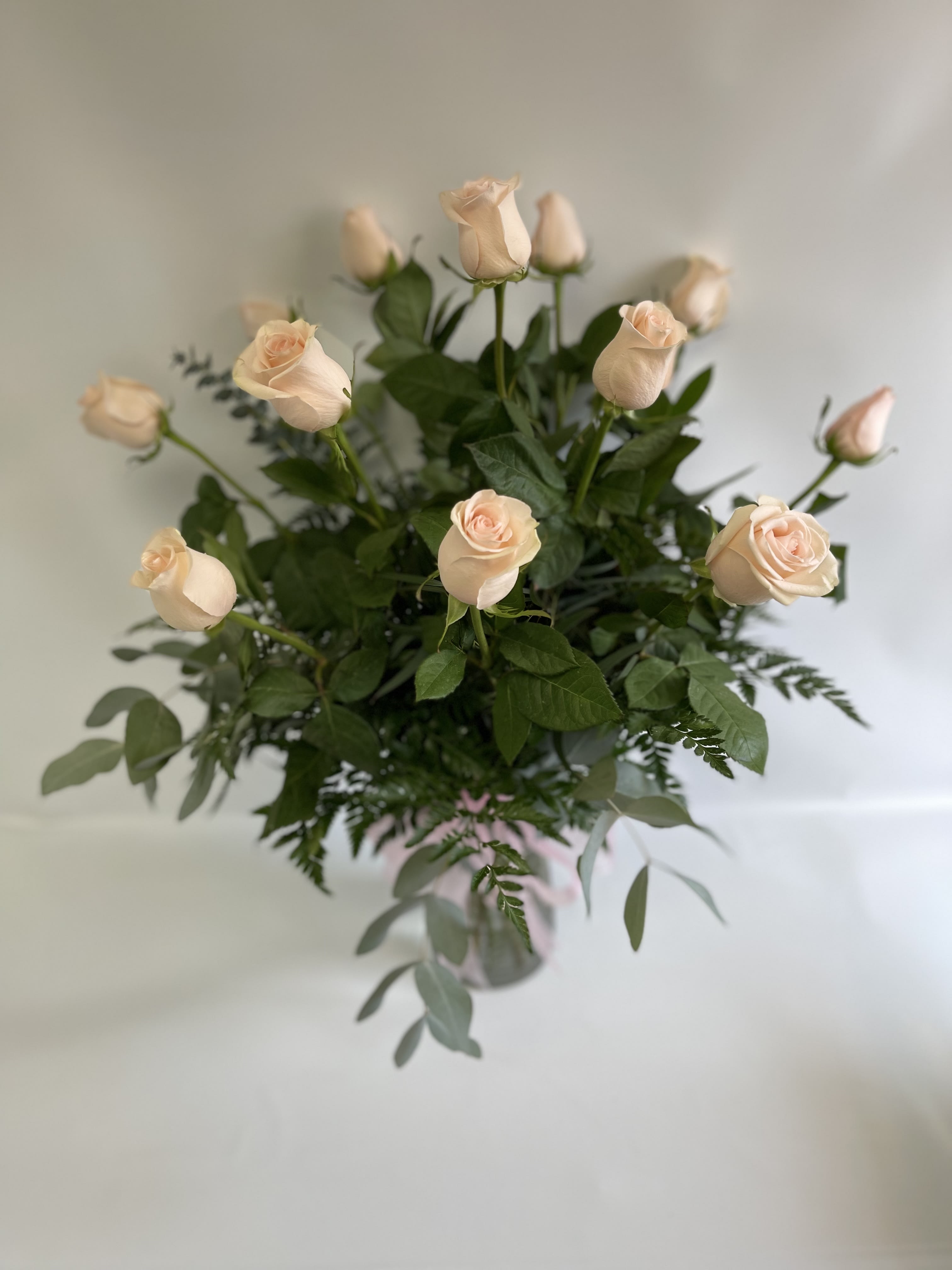 Bouquet of pale peach roses with greenery in a vase