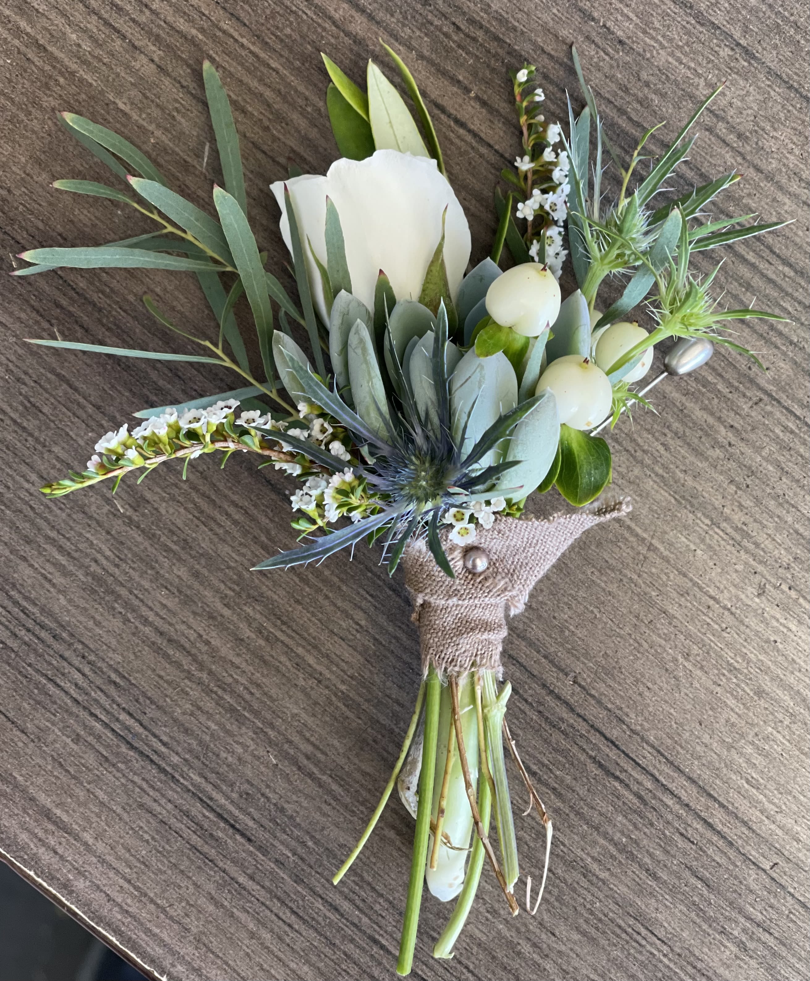 Boutonniere with a white rose and blue-green foliage