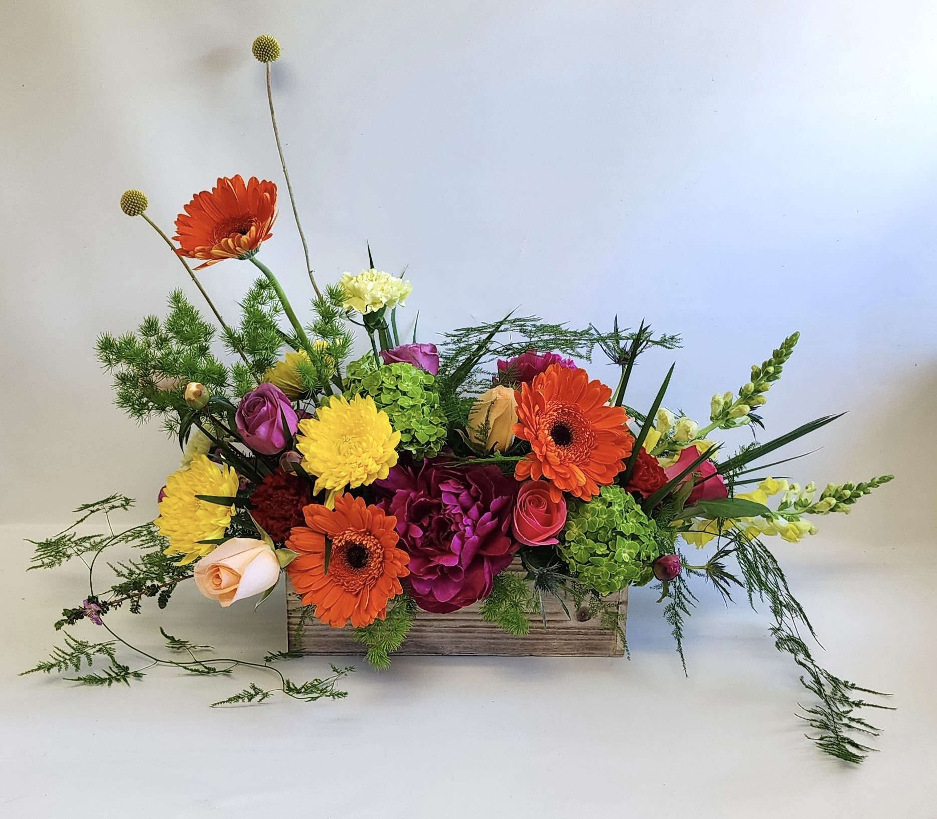 Sunshine and Sangria by Barb’s Flowers - This bright asymmetrical, colorful arrangement will bring a smile to anyone’s face for any occasion. If peonie are out of season, we will be subbing with other Flowers.