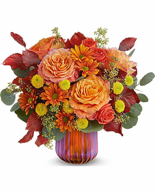 Teleflora's Sunset Shine Bouquet - Teleflora's Sunset Shine Bouquet glows with radiant orange blooms and golden accents, gathered in Teleflora's Amber Glow Votive. With its iridescent finish, this luminous fall centerpiece captures the warmth of sunset-and shines on as a votive after the blooms are gone.