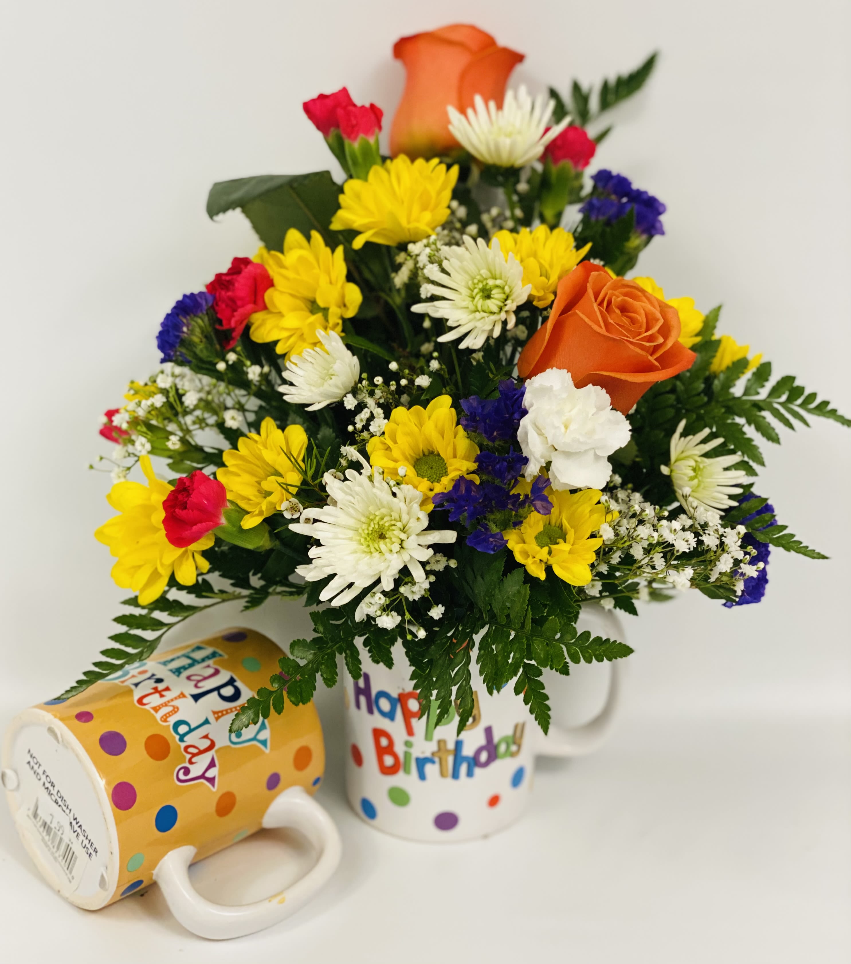 Birthday bouquet in a mug with yellow, white, red, and orange flowers