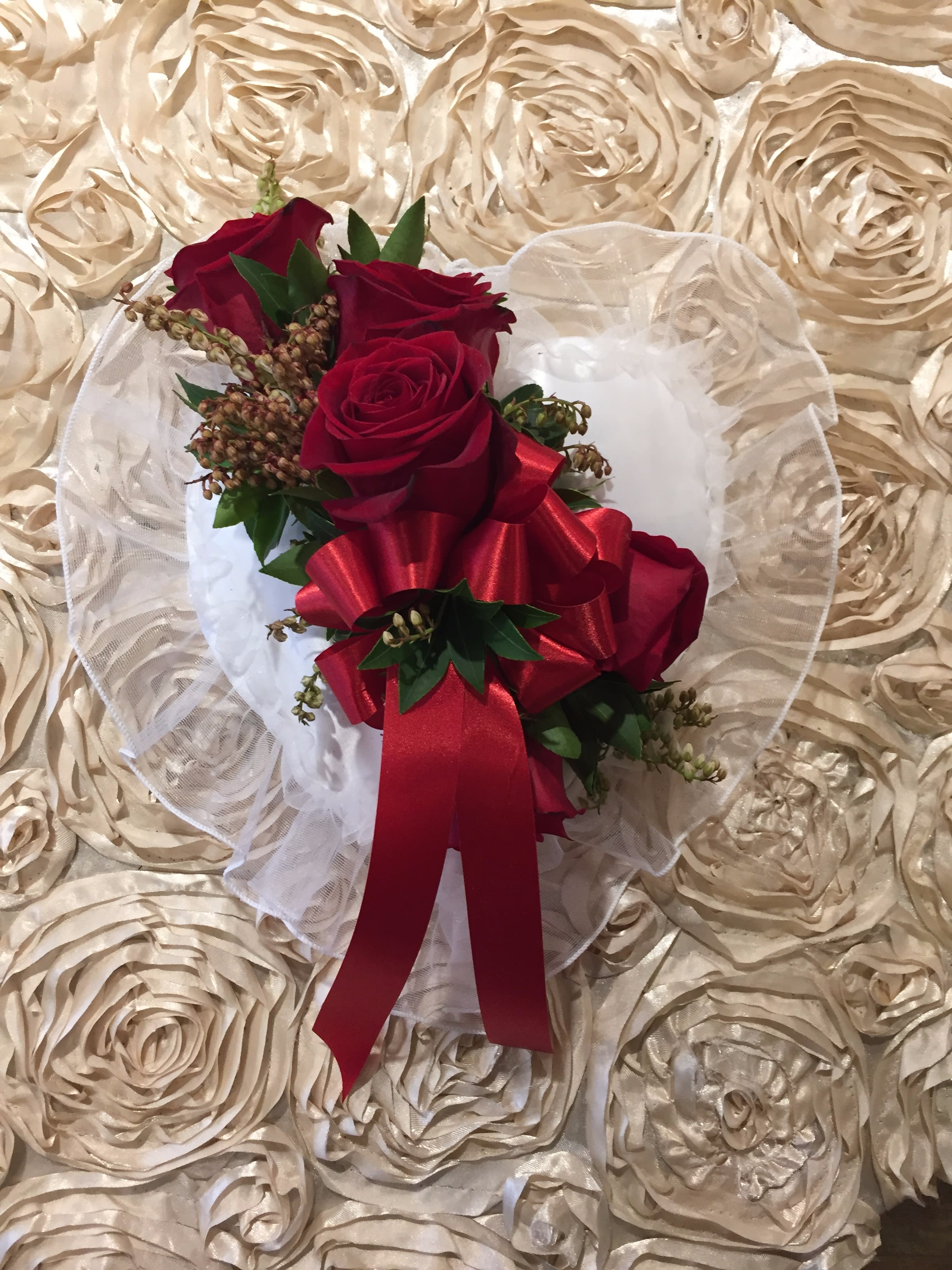 Red rose bouquet with a large red ribbon on white tulle