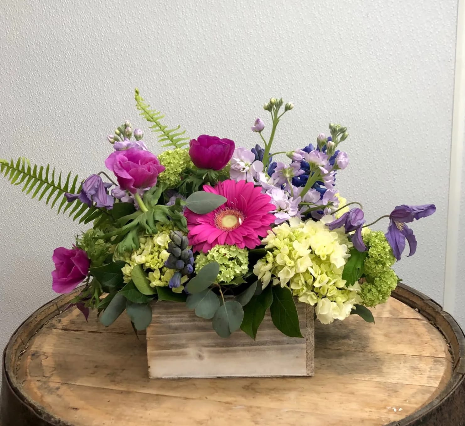 Mixed bouquet with pink and purple flowers in a wooden box