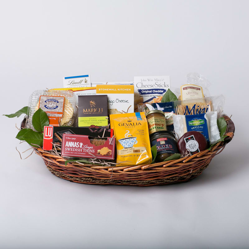 Gift basket with assorted packaged snacks and chocolates in a wicker tray