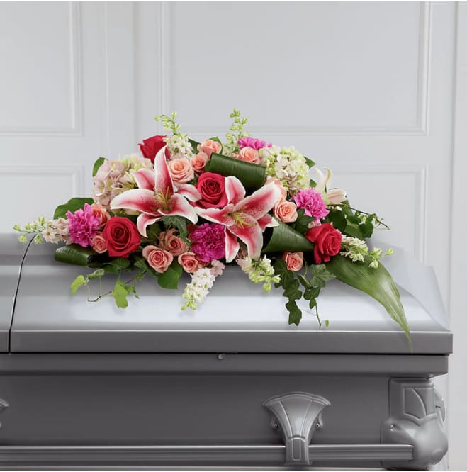 Pink and red floral casket spray with lilies and roses