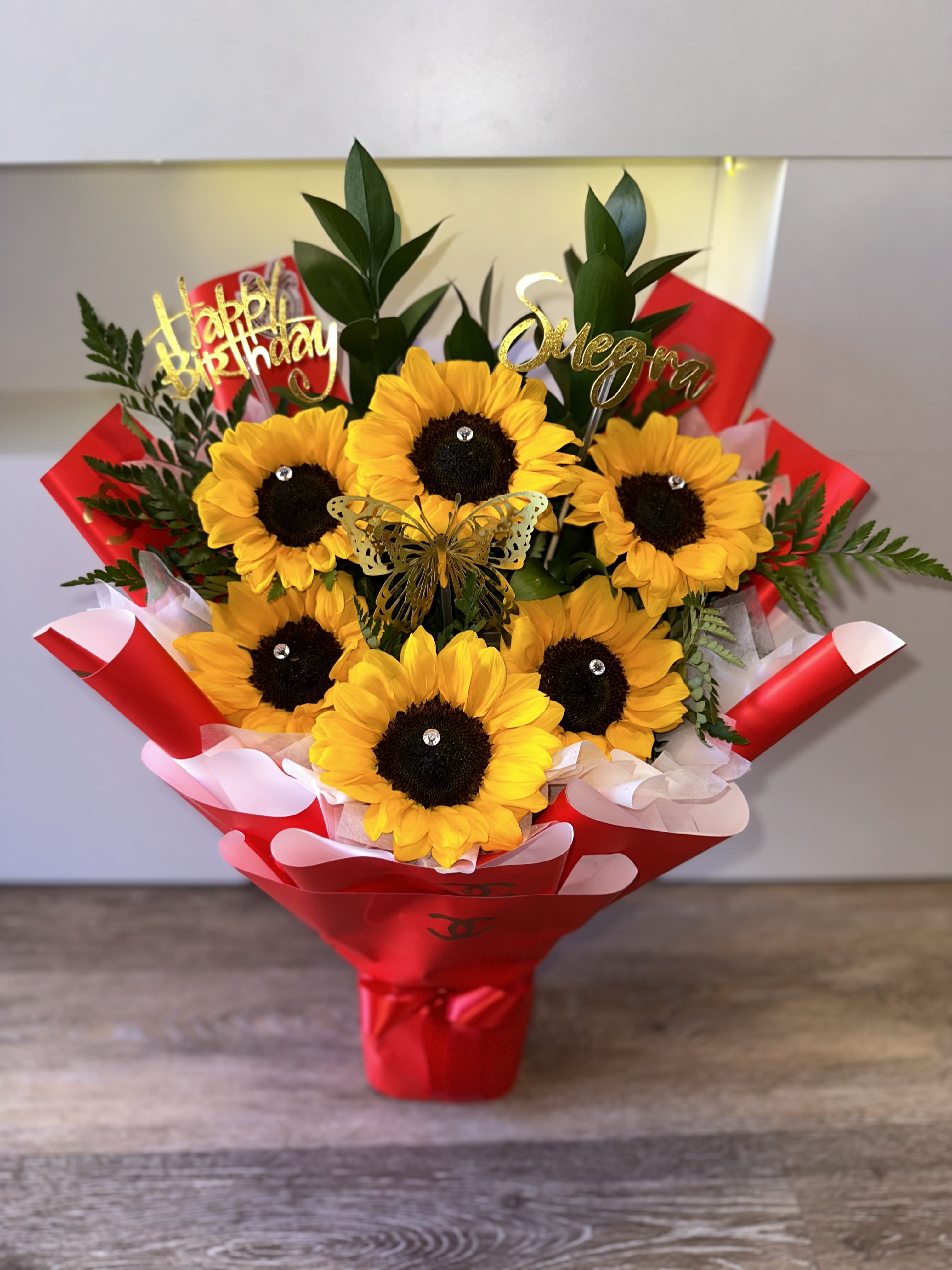 Sunflower bouquet in red wrapping with birthday toppers