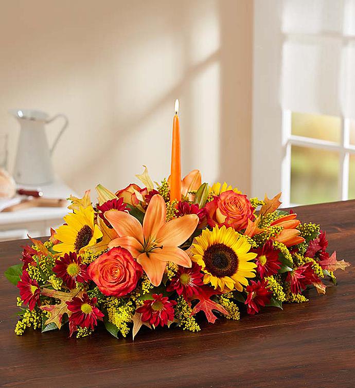 Fall Centerpiece with candle - Long and low table centerpiece with a mixed array of colors and flowers along with a taper candle