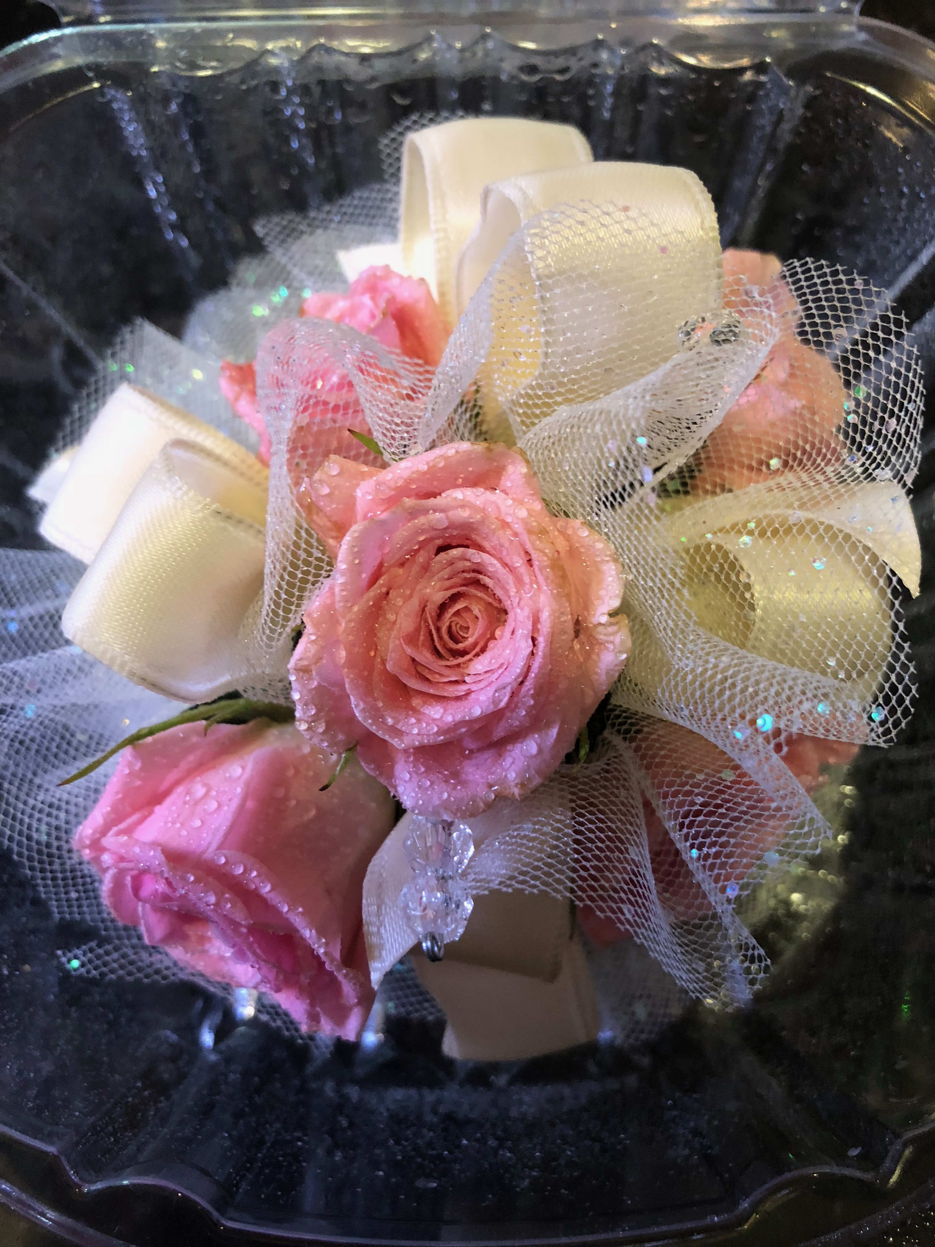 Pink roses with white ribbon and tulle in a black container