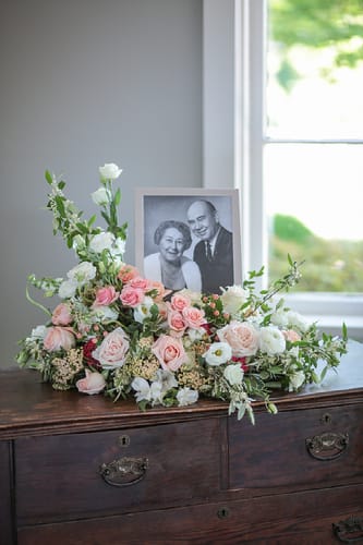 Pastel floral arrangement with a framed black-and-white portrait