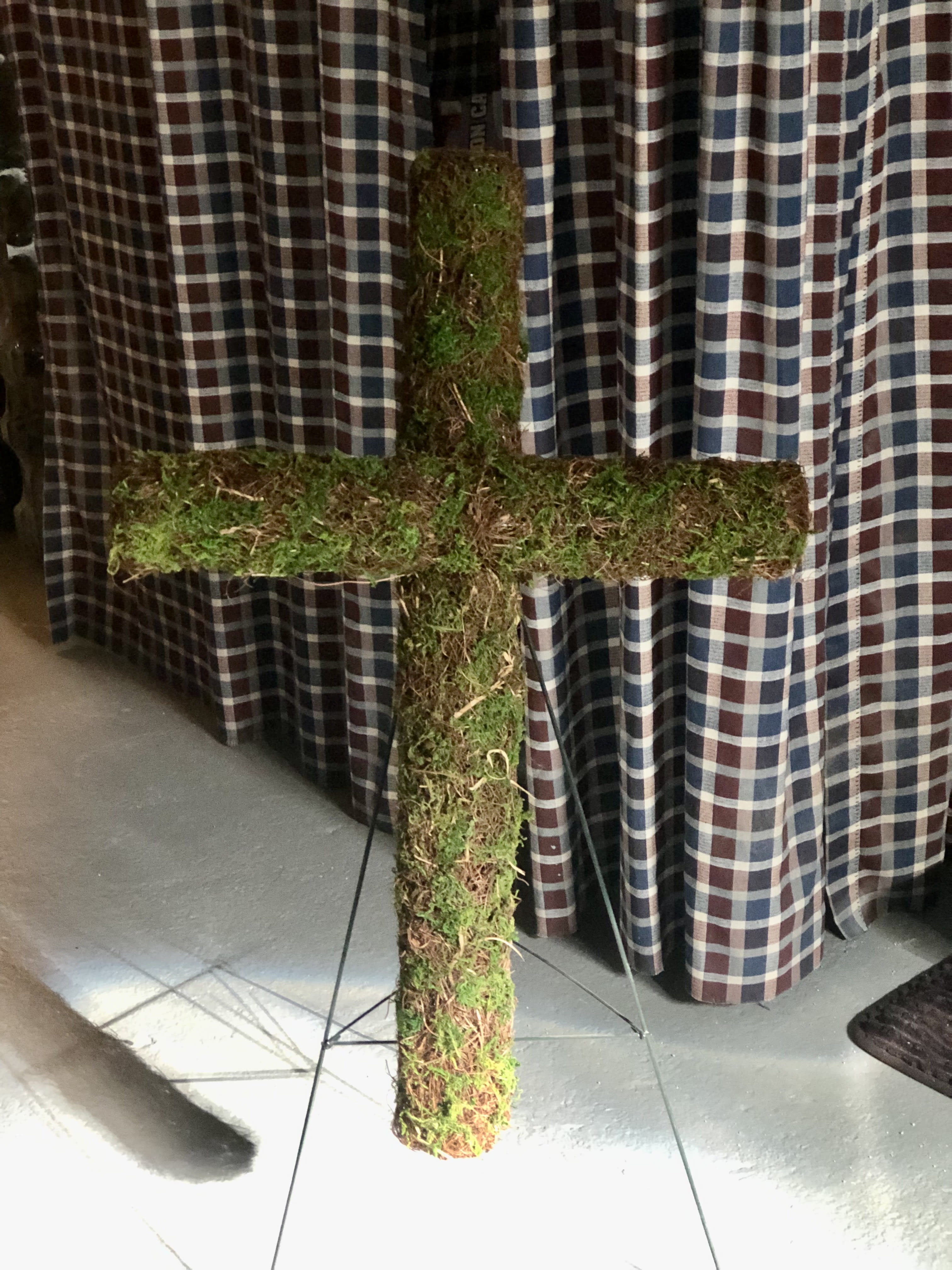 Moss-covered cross on a stand