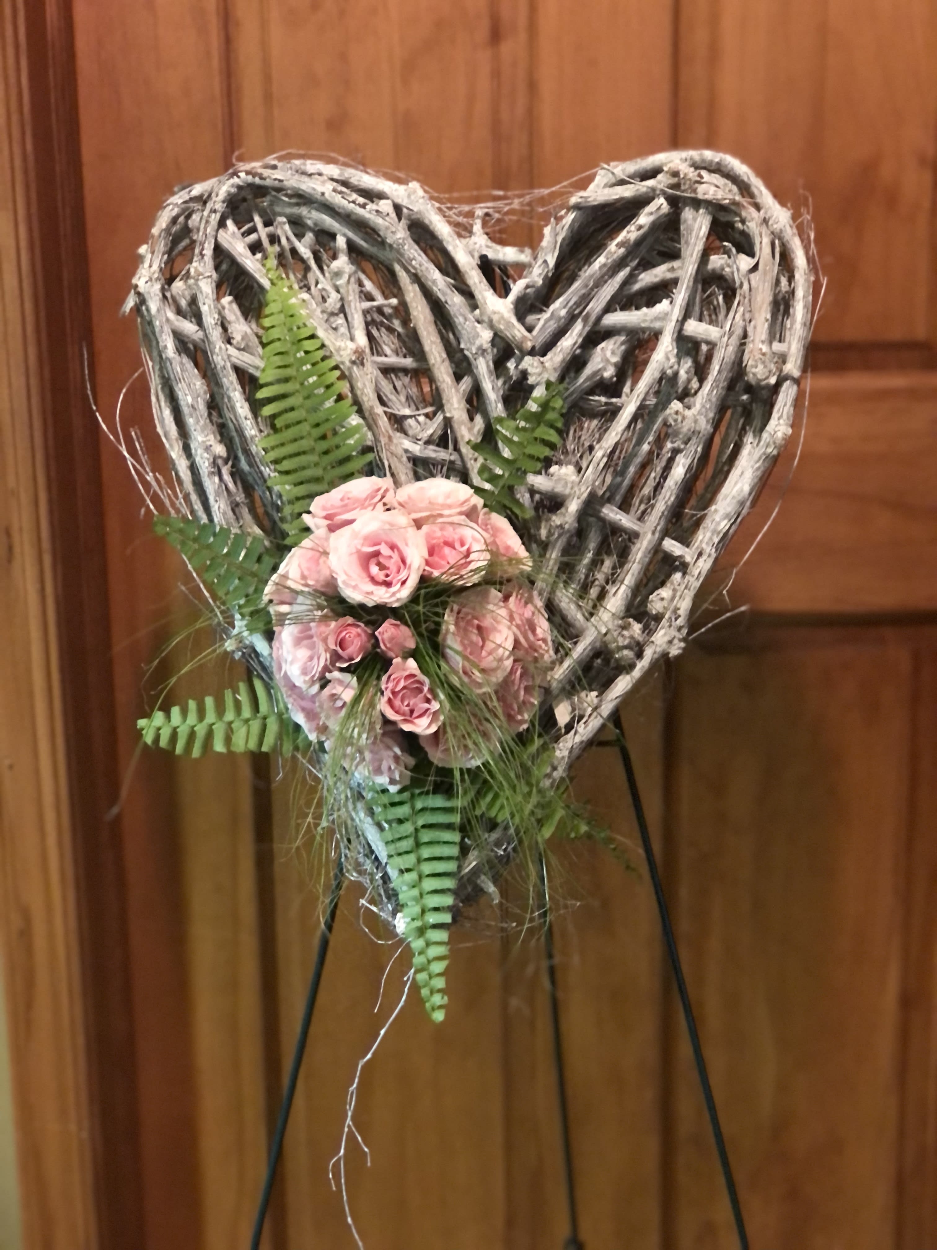 Heart-shaped twig wreath with pink roses and fern accents