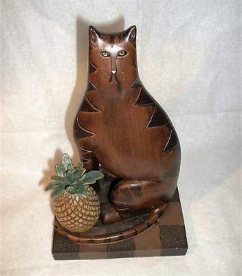 Wooden cat figurine holding a small potted succulent