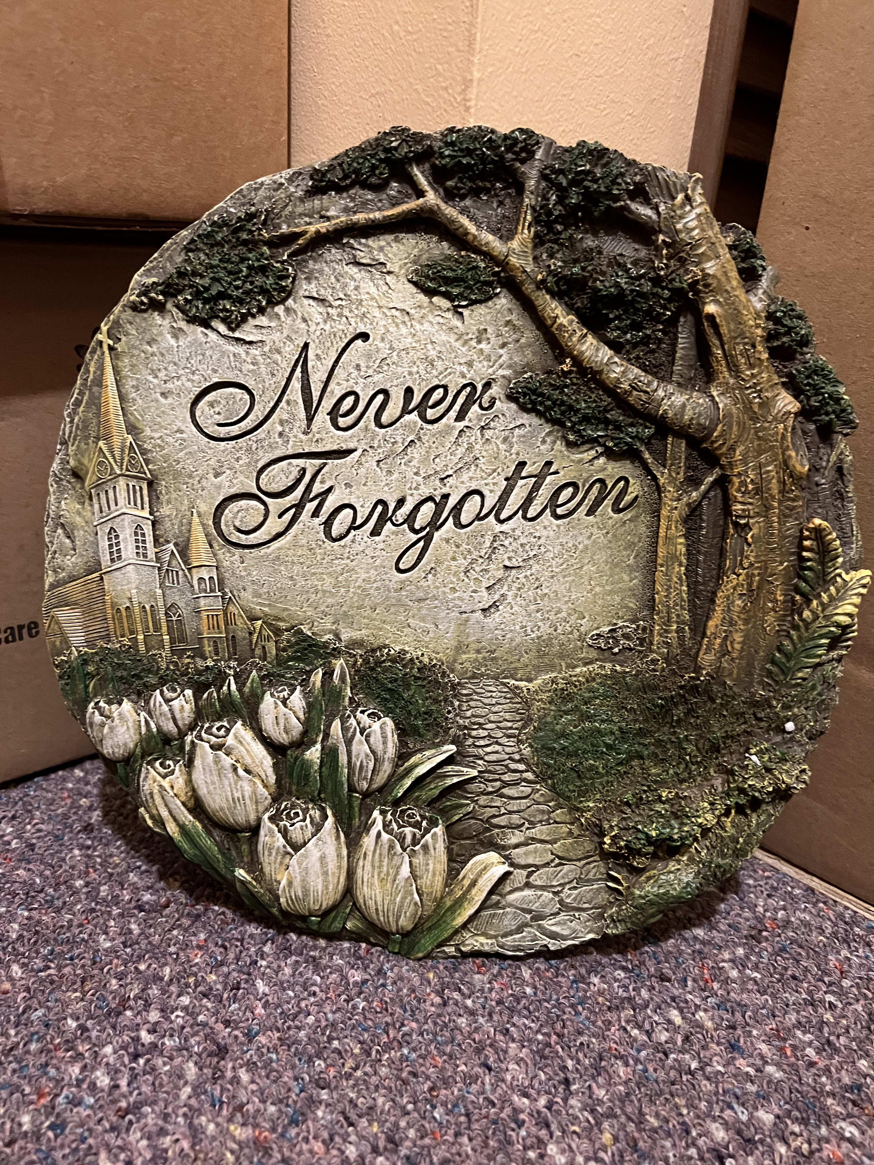Decorative stone plaque with tulips and the words "Never Forgotten"