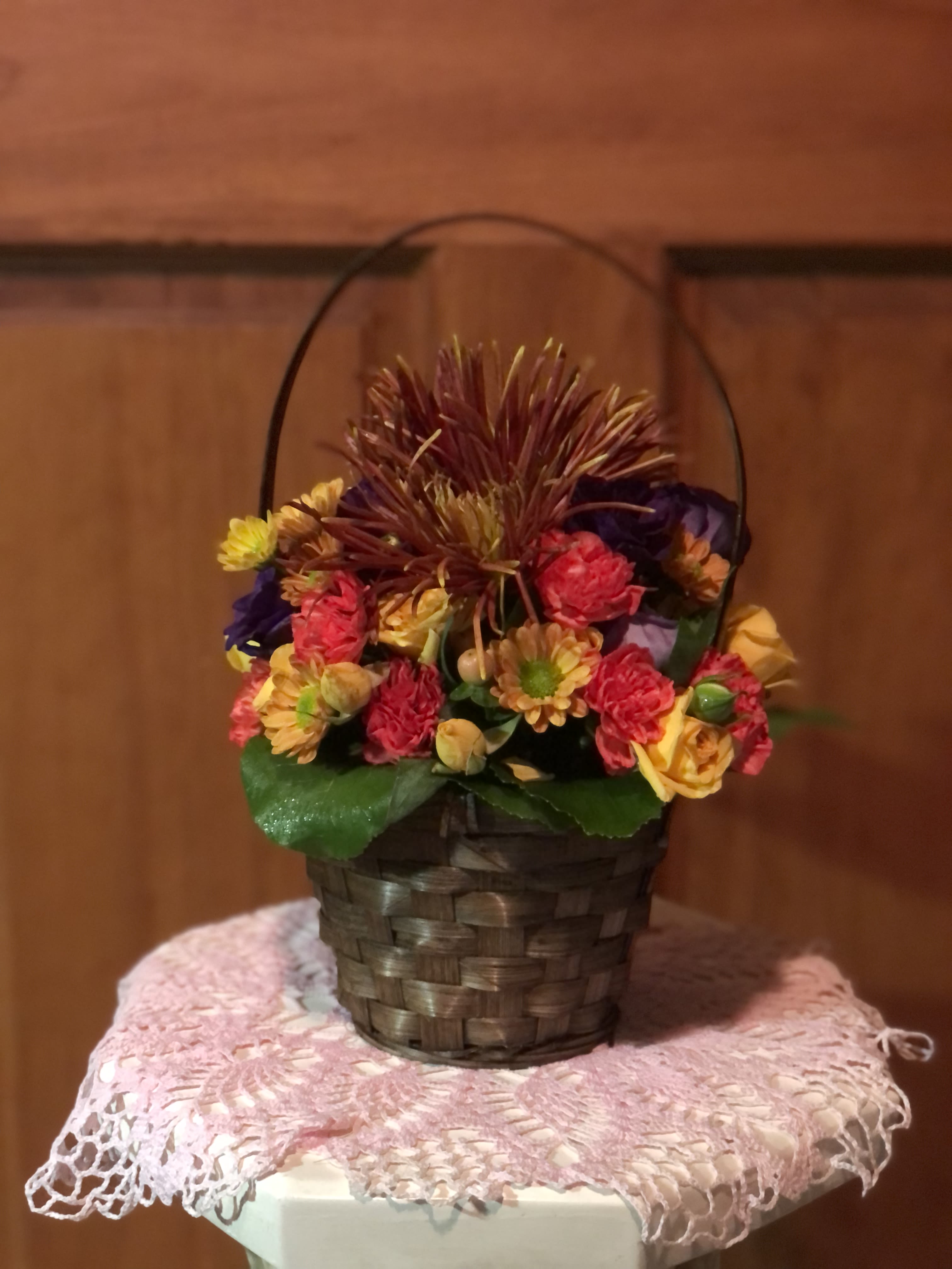 Mixed flowers in a woven basket with a handle