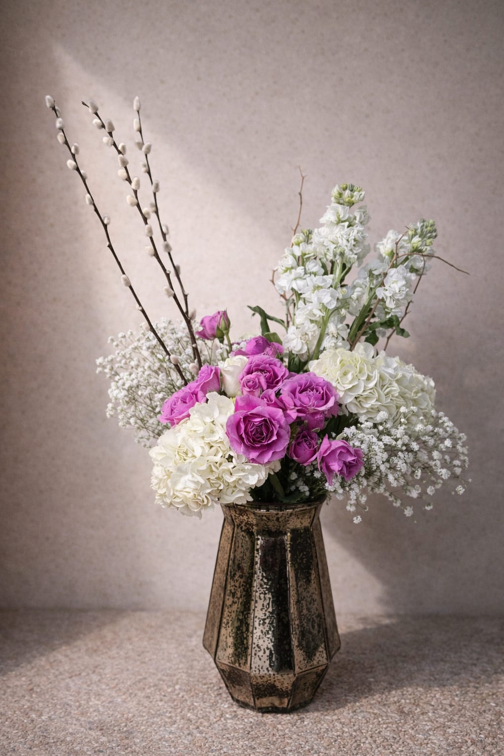 Pink and white roses with hydrangeas in a dark glass vase