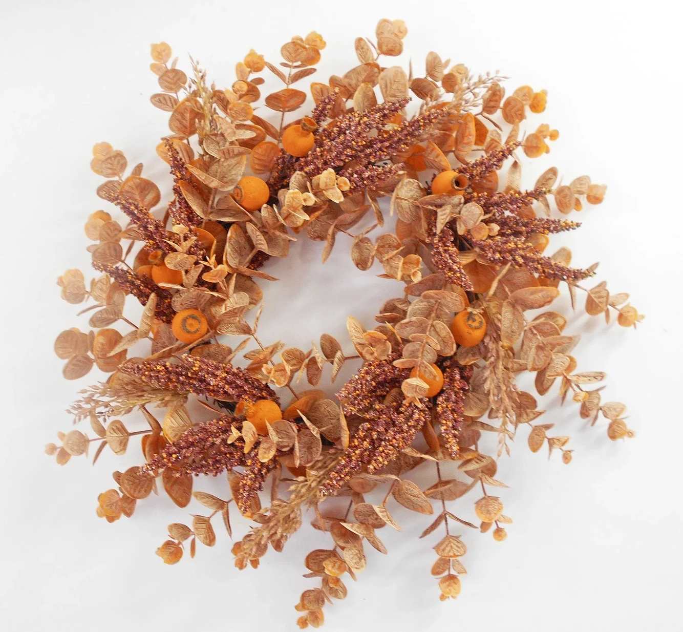 Autumn wreath with orange berries and dried foliage on a white background