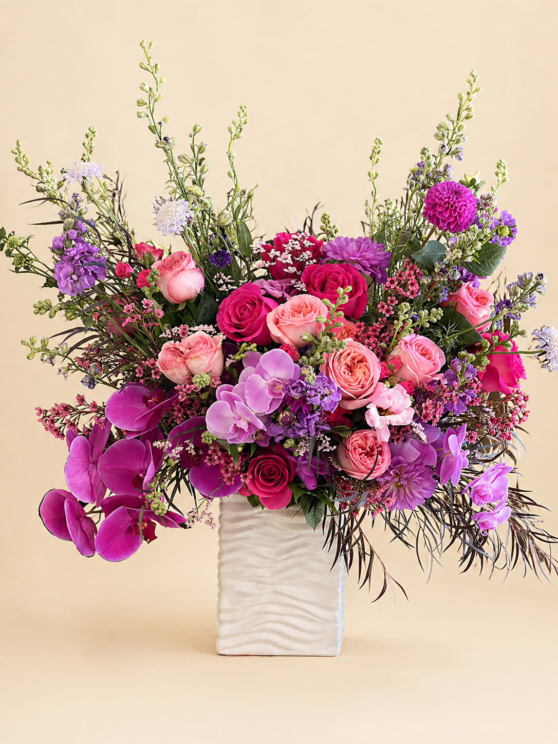 Pink and purple mixed flower arrangement in a white vase