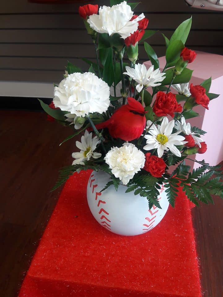 Red and white floral arrangement in a round white vase