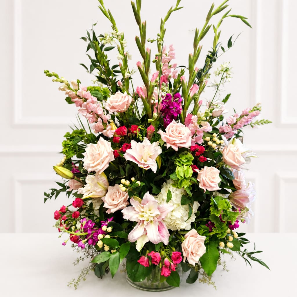 Large mixed bouquet of pink and white flowers in a glass vase