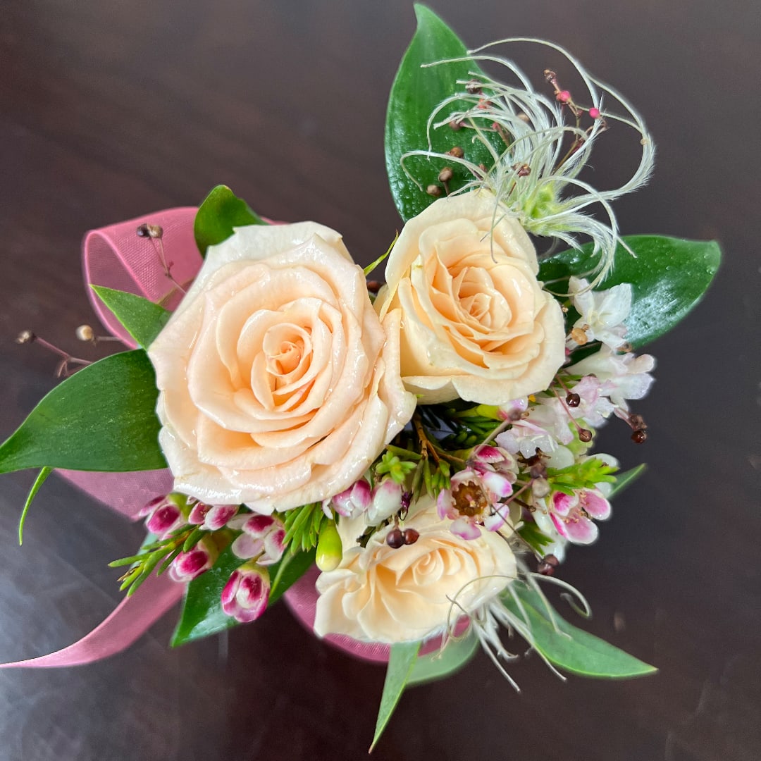 Peach roses with small pink-and-white flowers and ribbon wrap