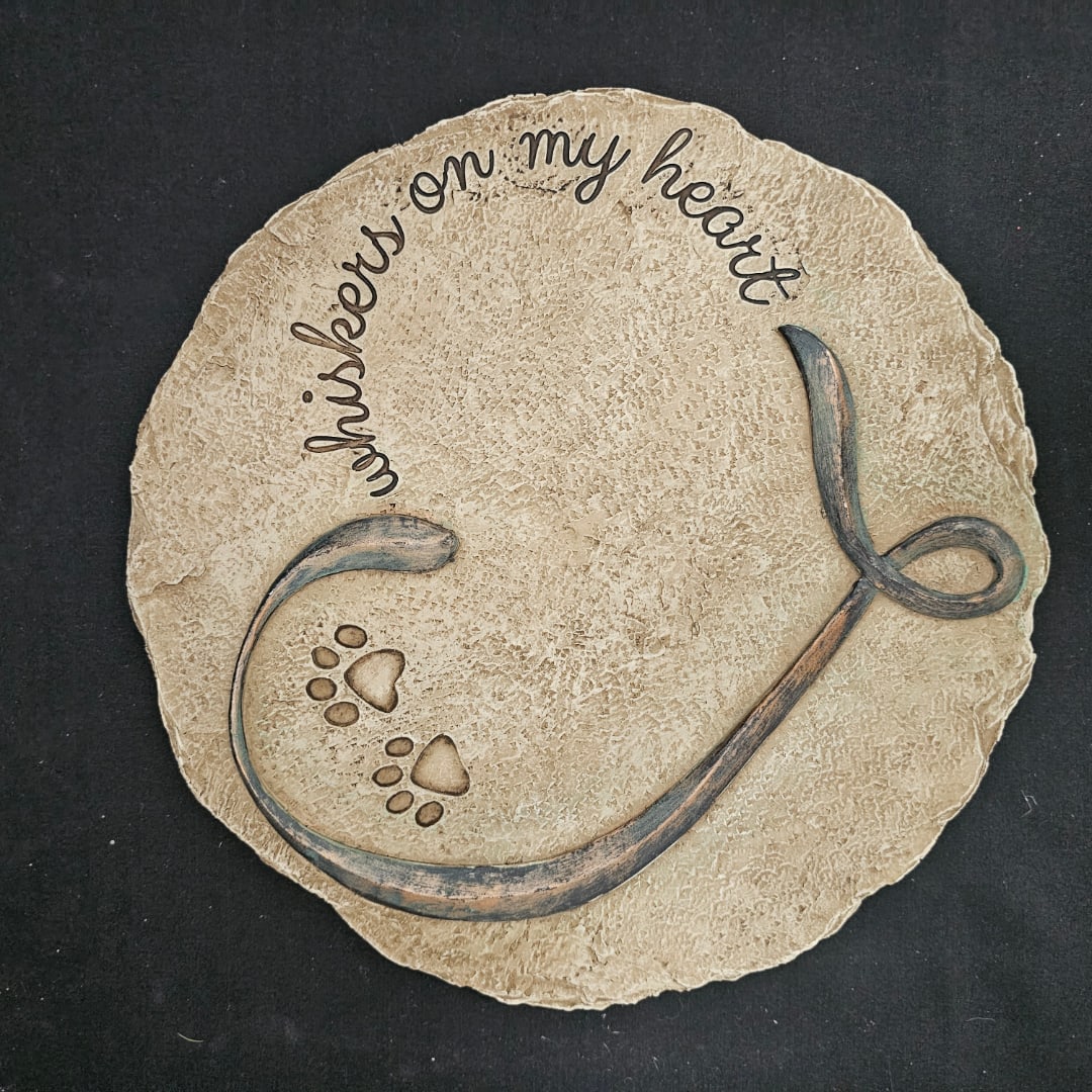 Round textured plaque with the words "whispers on my heart" and paw prints