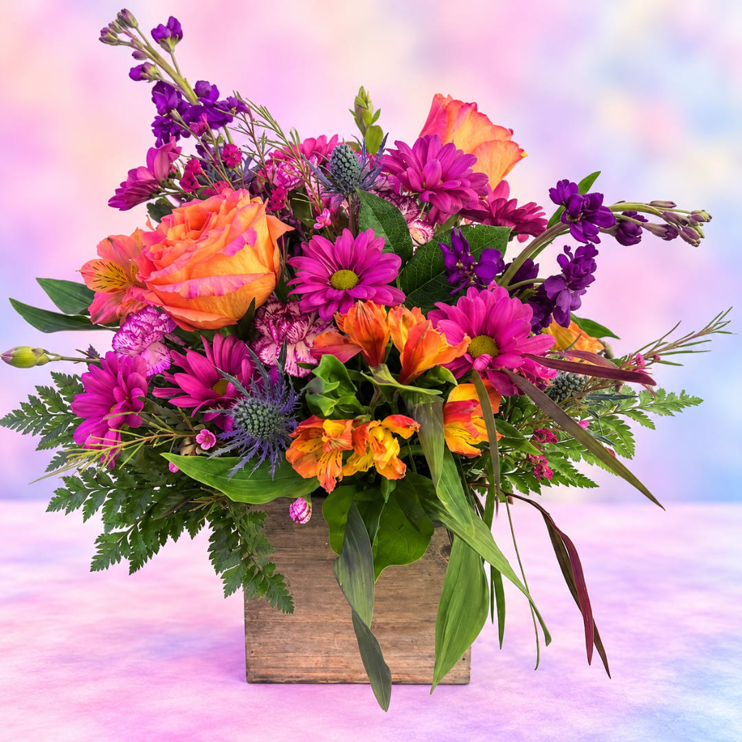 Bright mixed bouquet in a wooden box with orange roses and purple daisies