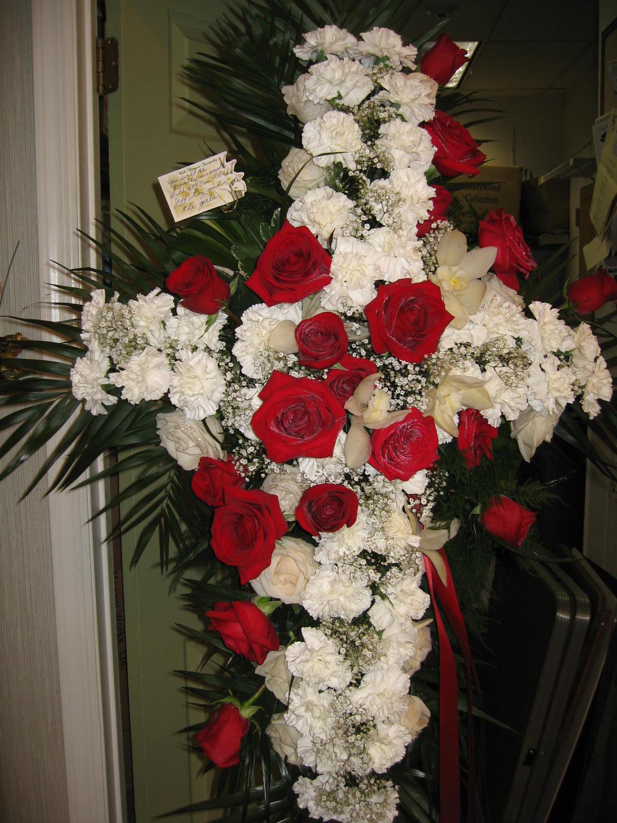 Cross-shaped floral spray with red roses and white carnations