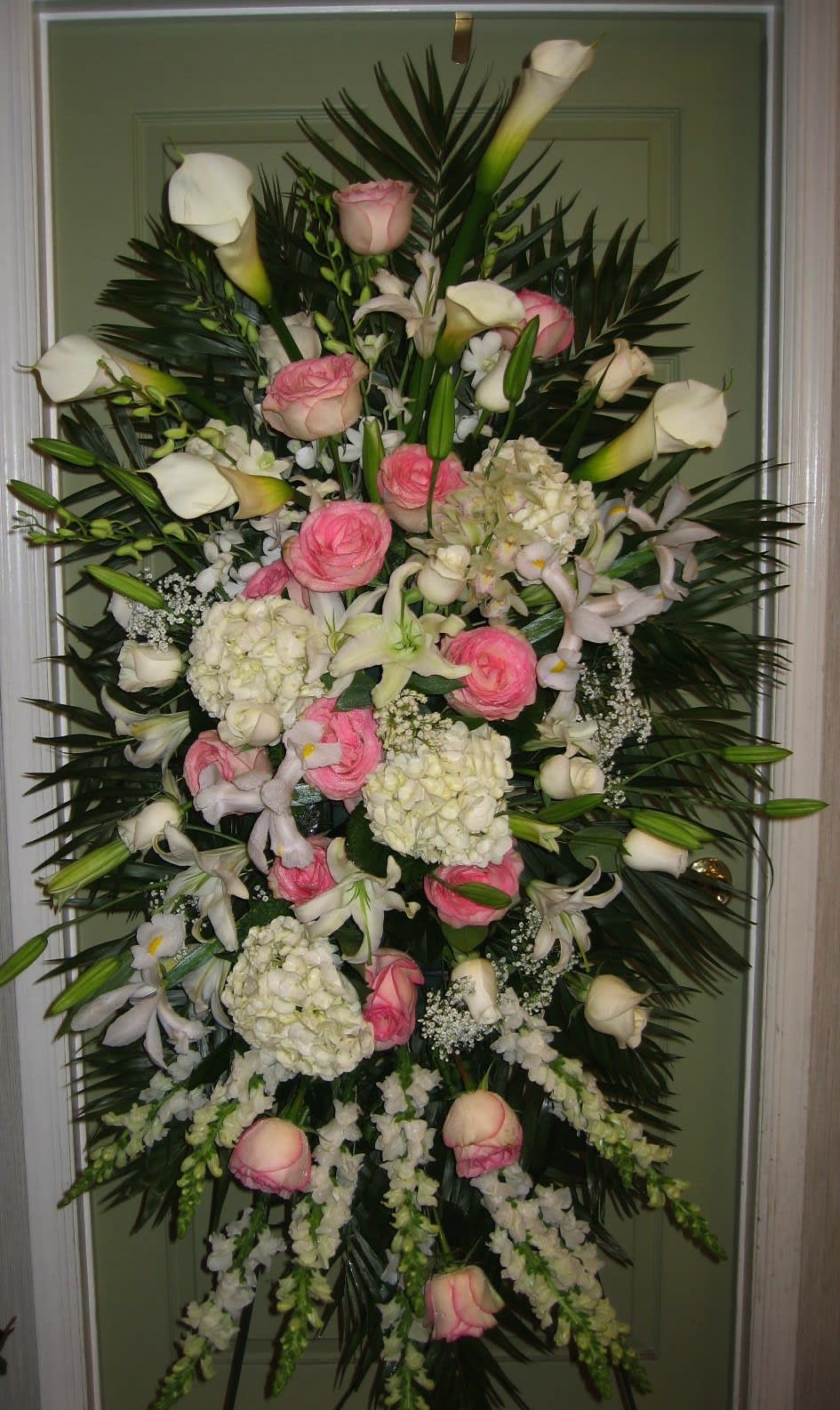 Tall standing floral spray with pink roses, white calla lilies, and white hydrangeas