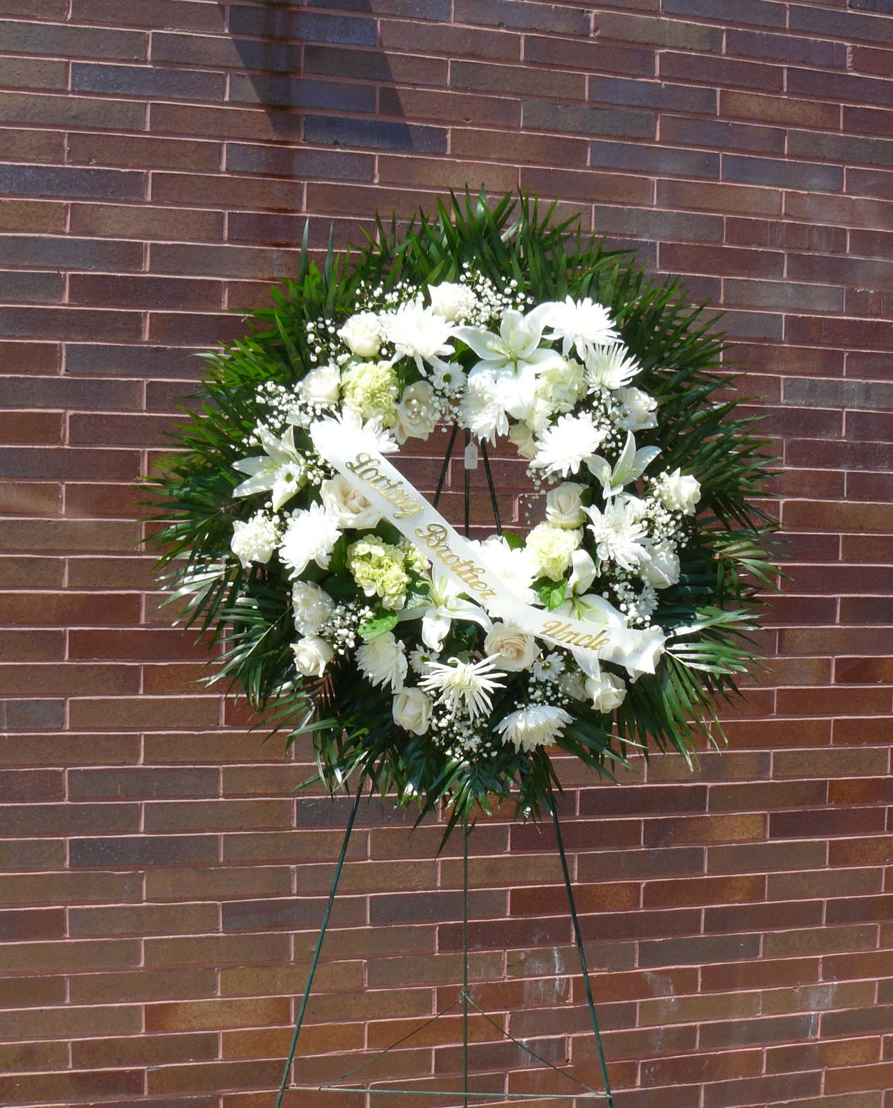 White funeral wreath on a stand with a ribbon