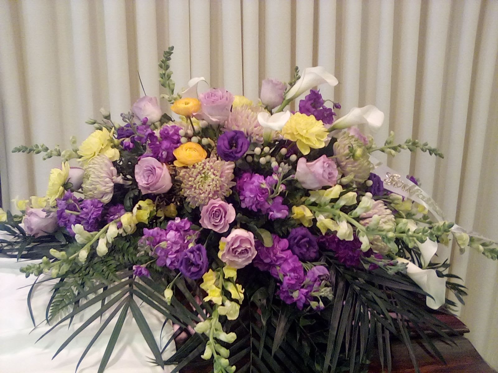 Large floral arrangement with purple, pink, yellow, and white blooms