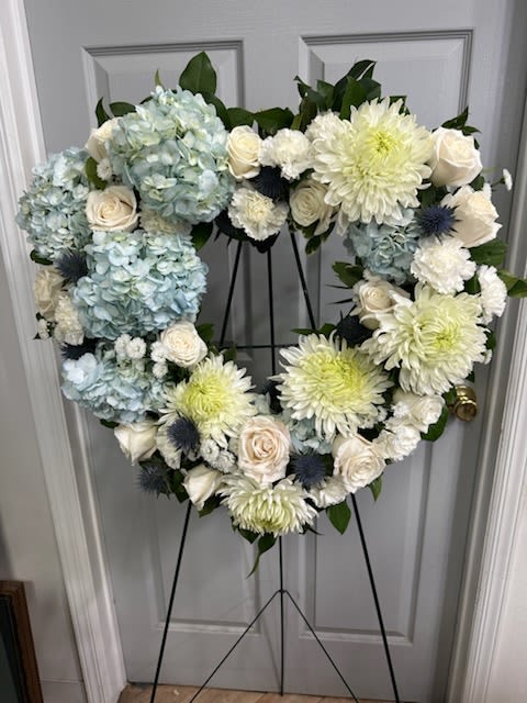 Heart-shaped floral wreath with blue hydrangeas, white roses, and pale chrysanthemums