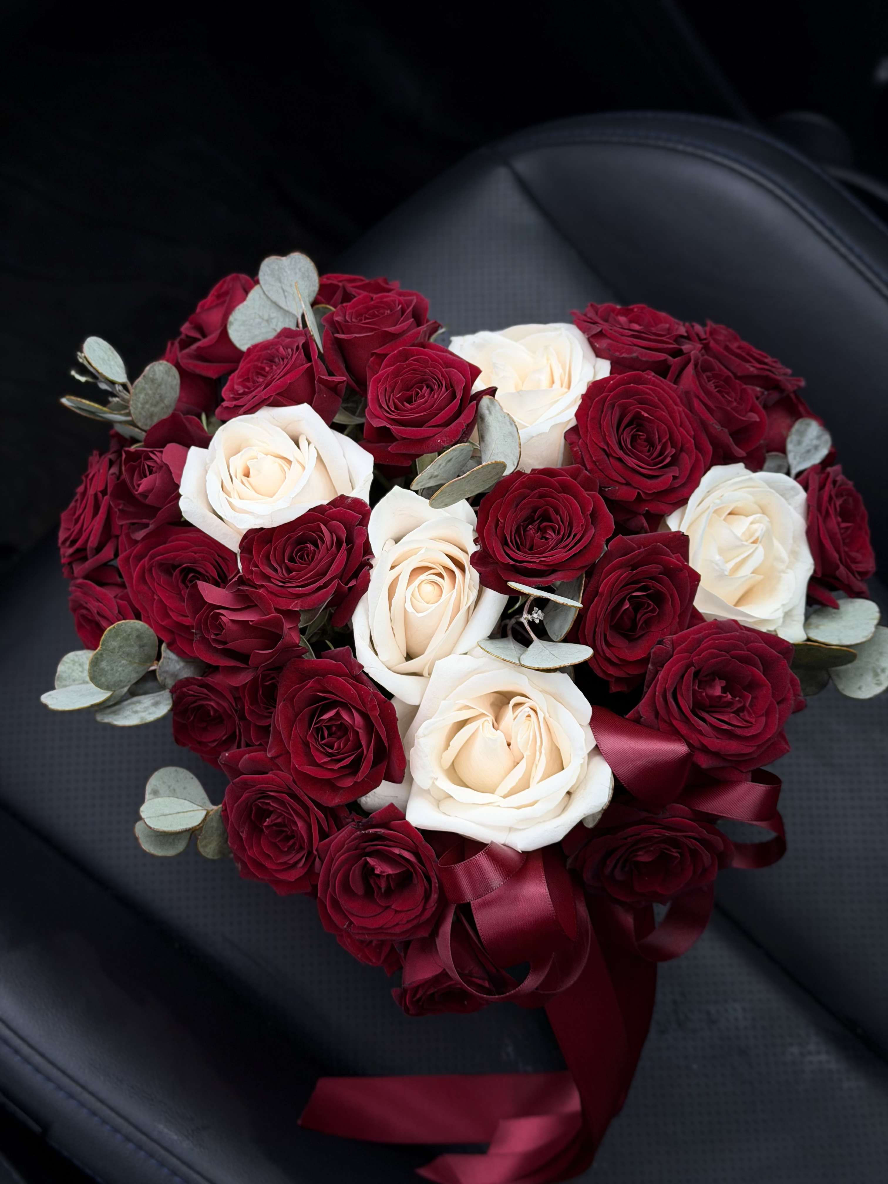 Heart-shaped bouquet of red and white roses with ribbon