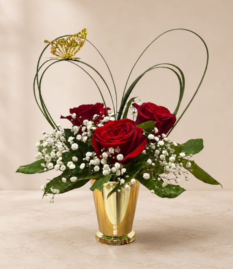 Red roses with baby's breath in a gold vase and butterfly accent