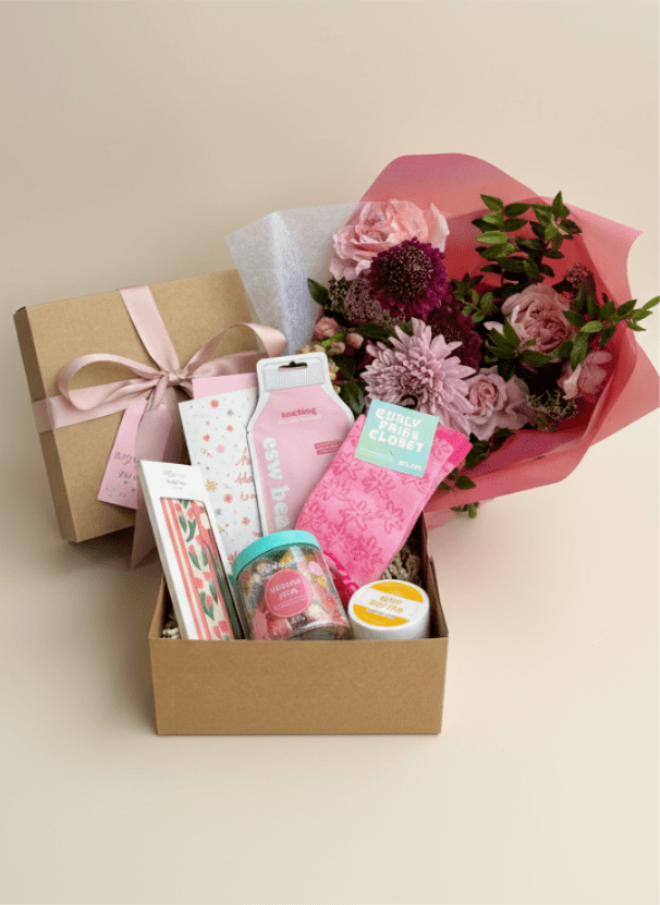 Gift box with pink flowers and assorted self-care items