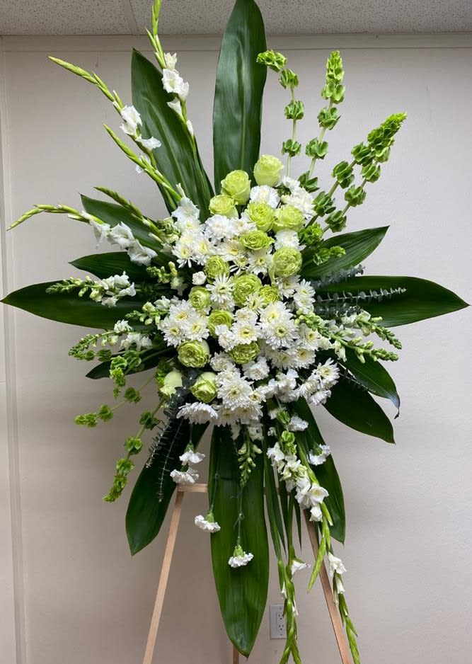 Tall white and green floral standing arrangement on an easel