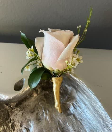 Single pale pink rose with small white accent flowers