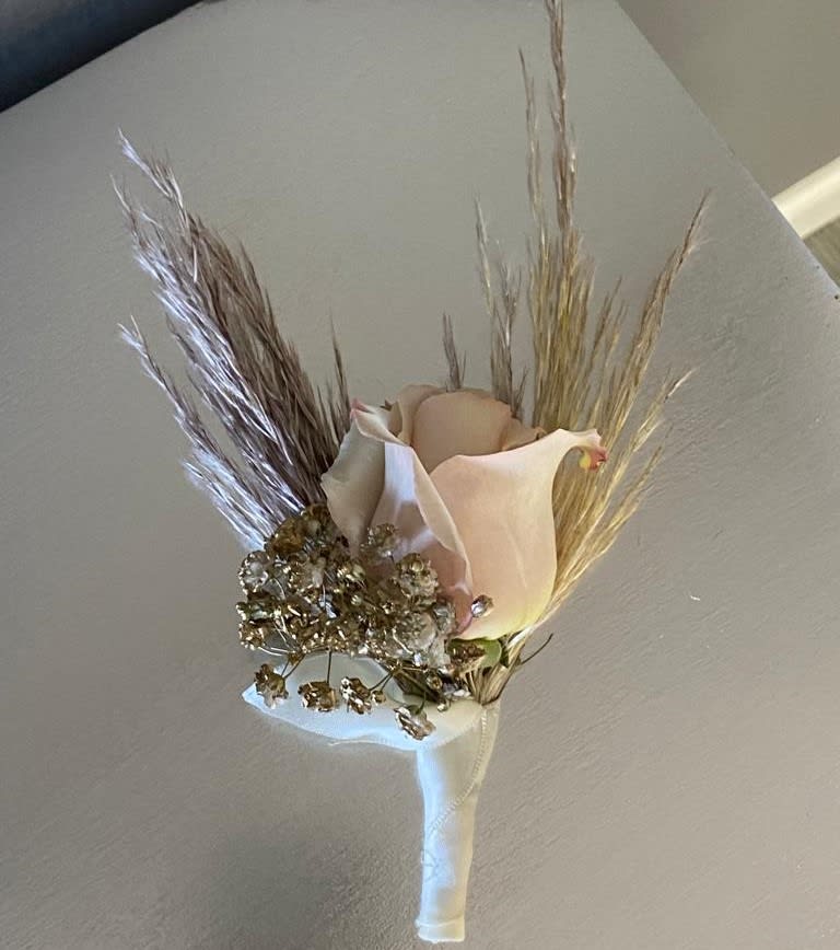 Boutonniere with a pale calla lily and dried grasses