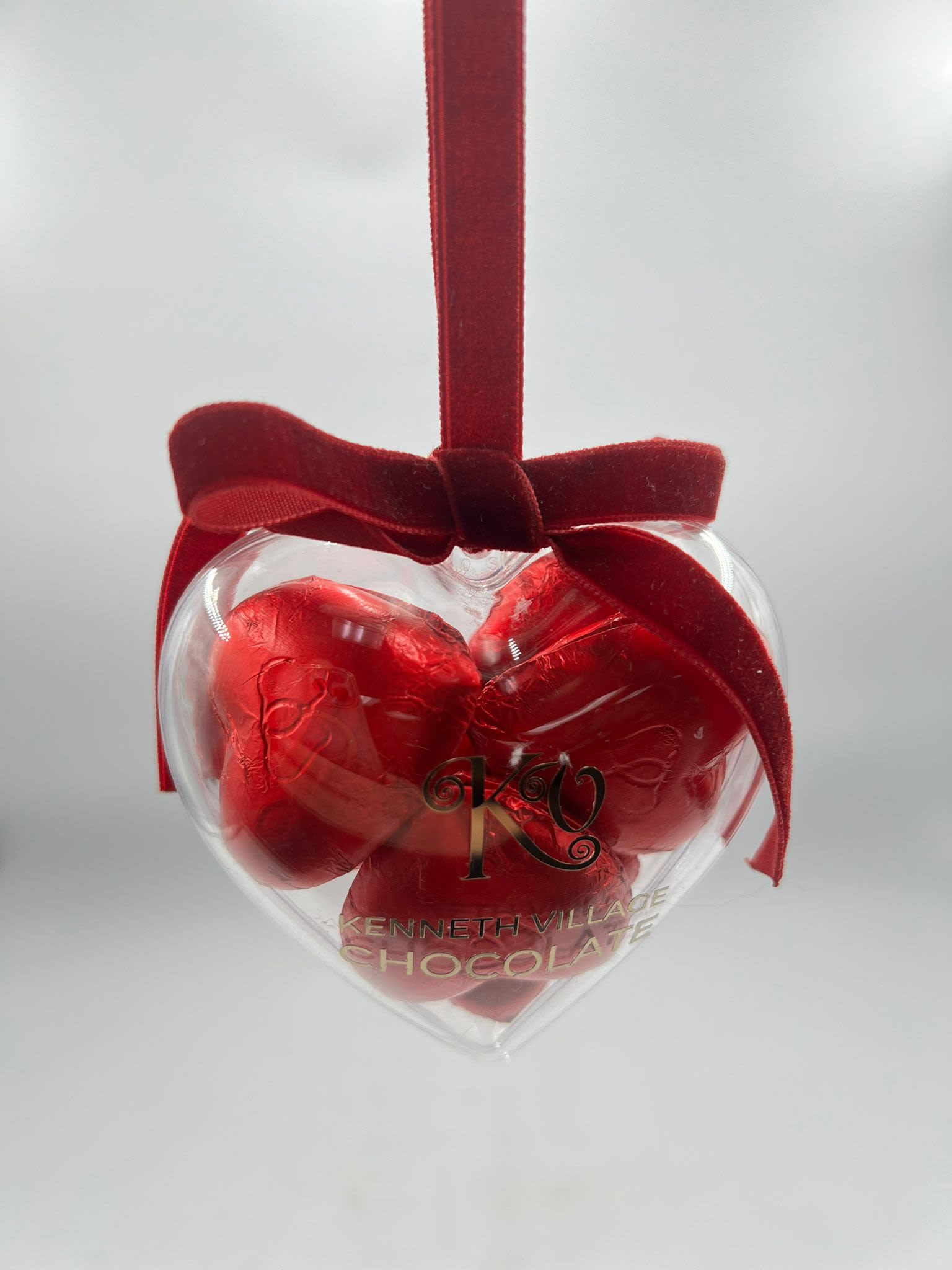 Heart-shaped chocolate gift box with a red ribbon bow